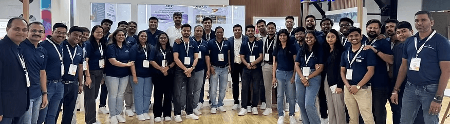 A corporate team wearing matching navy COTTSON polos at an exhibition