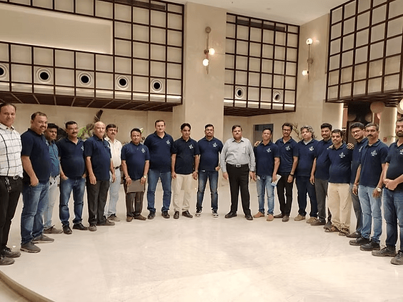 A team in navy COTTSON polos standing together in a hotel lobby